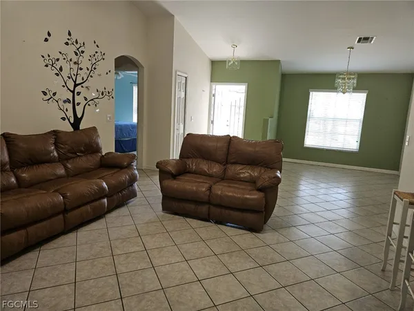 a living room with furniture and a chandelier