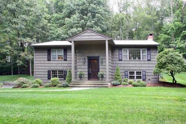 322 Georgetown Road Weston, CT 06883 - Photo 1 of 1 a front view of a house with a yard