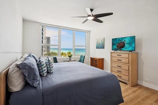 a bed room with a bed a dresser and a potted plant