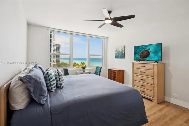 a bed room with a bed a dresser and a potted plant