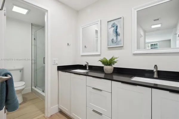 a bathroom with a granite countertop sink a toilet and a mirror