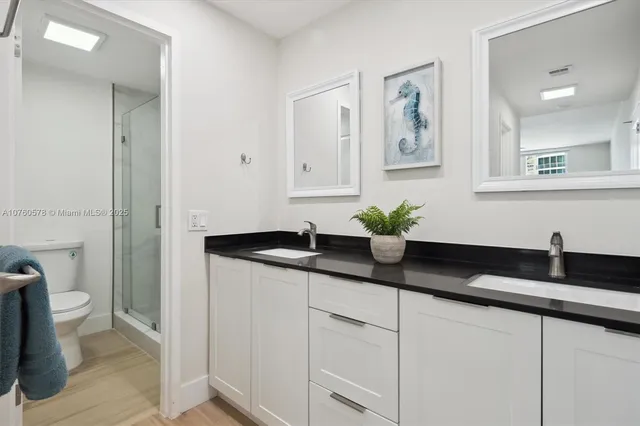 a bathroom with a granite countertop sink a toilet and a mirror