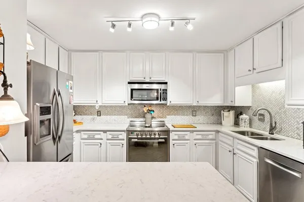 a kitchen with cabinets a sink and stainless steel appliances