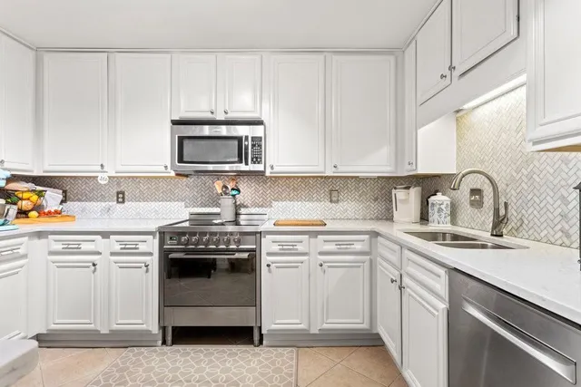 a kitchen with appliances a sink and cabinets