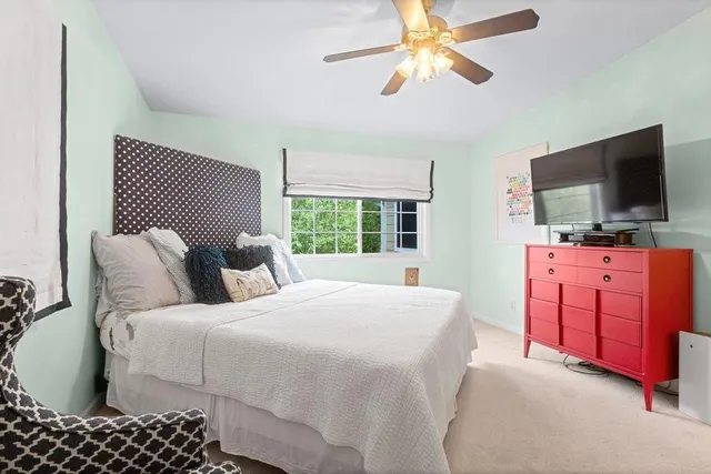 a bedroom with a bed and a flat tv screen on dresser