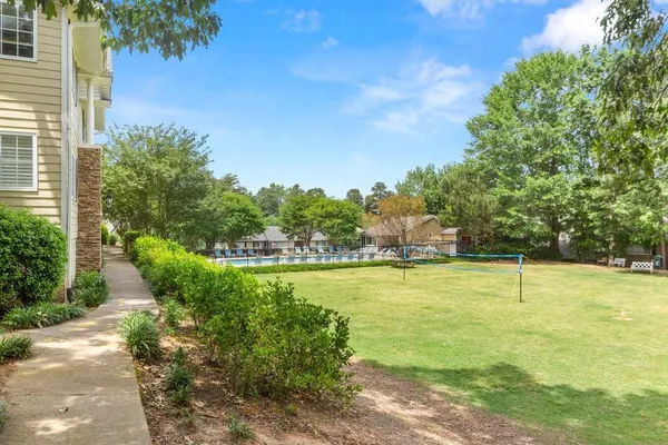 a view of a swimming pool with a patio and a yard