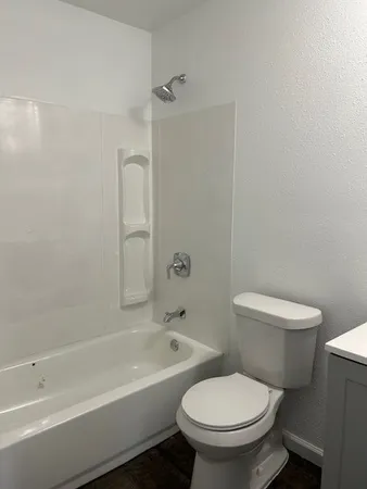 a white toilet and a bath tub sitting next to a white sink