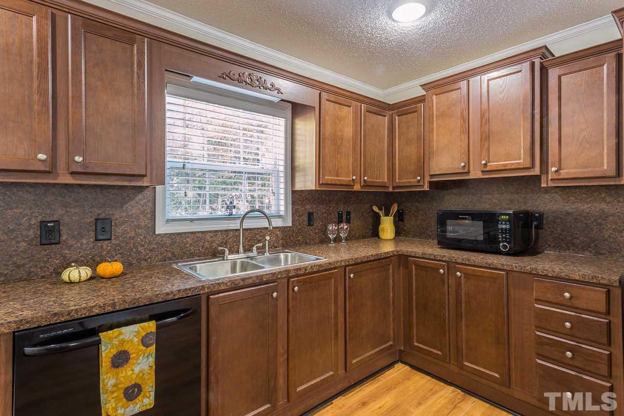 1001 Altice Drive Raleigh, NC 27603 - Photo 14 of 24 a kitchen with a sink a window and cabinets