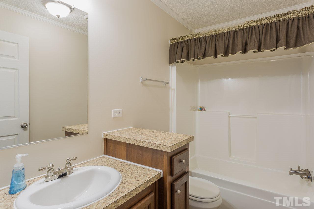 1001 Altice Drive Raleigh, NC 27603 - Photo 21 of 24 a bathroom with a granite countertop sink toilet a mirror and bathtub