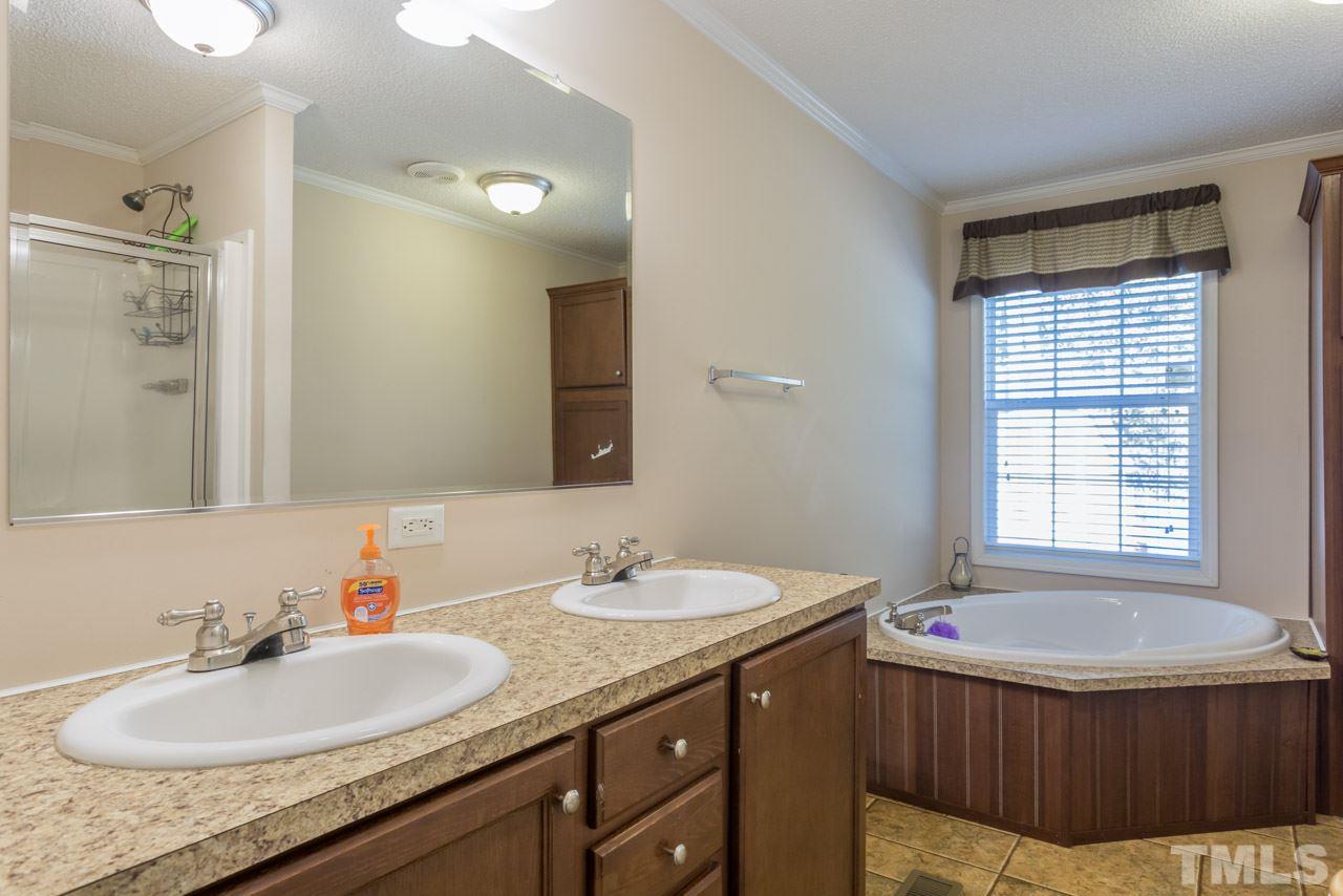 1001 Altice Drive Raleigh, NC 27603 - Photo 22 of 24 a bathroom with a granite countertop sink and a mirror