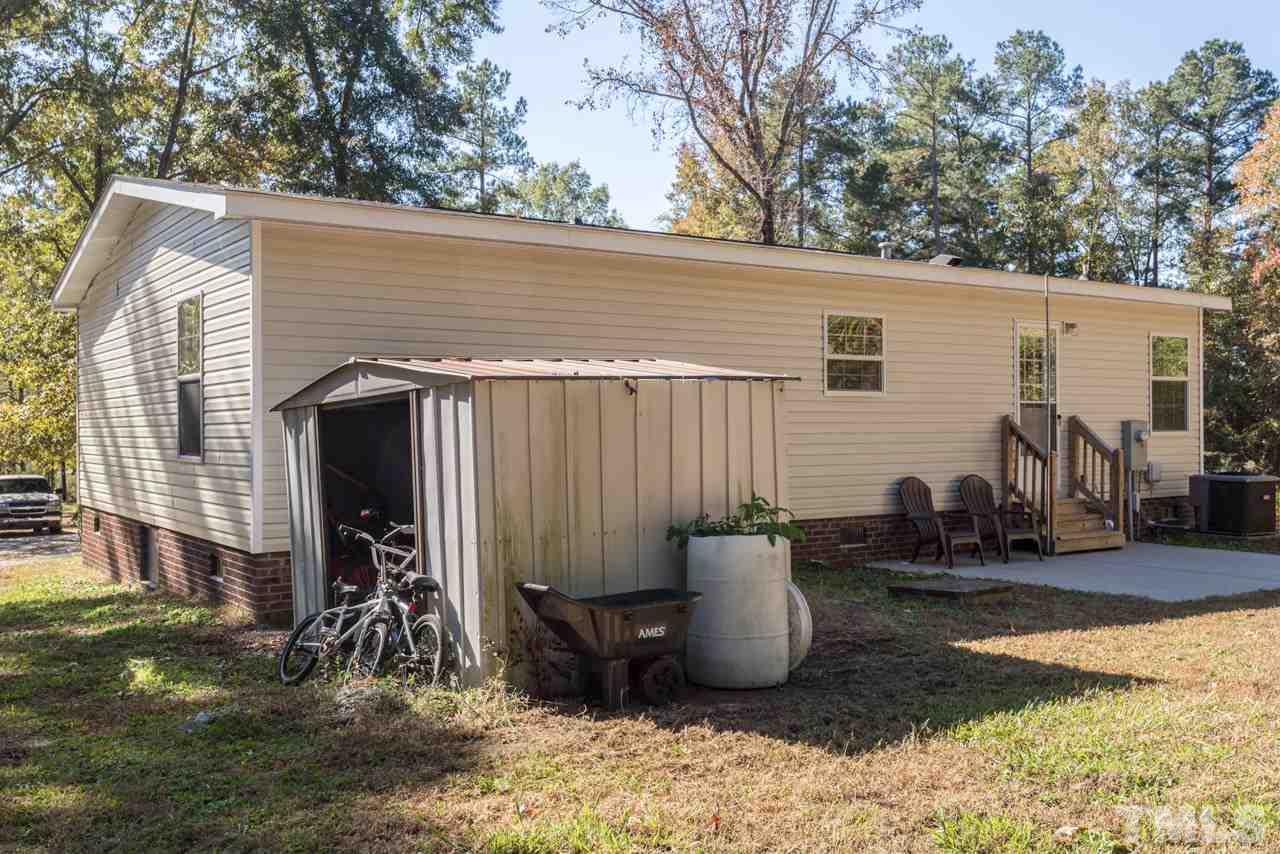 1001 Altice Drive Raleigh, NC 27603 - Photo 5 of 24 a view of a patio with table and chairs a barbeque with potted plants and a large tree