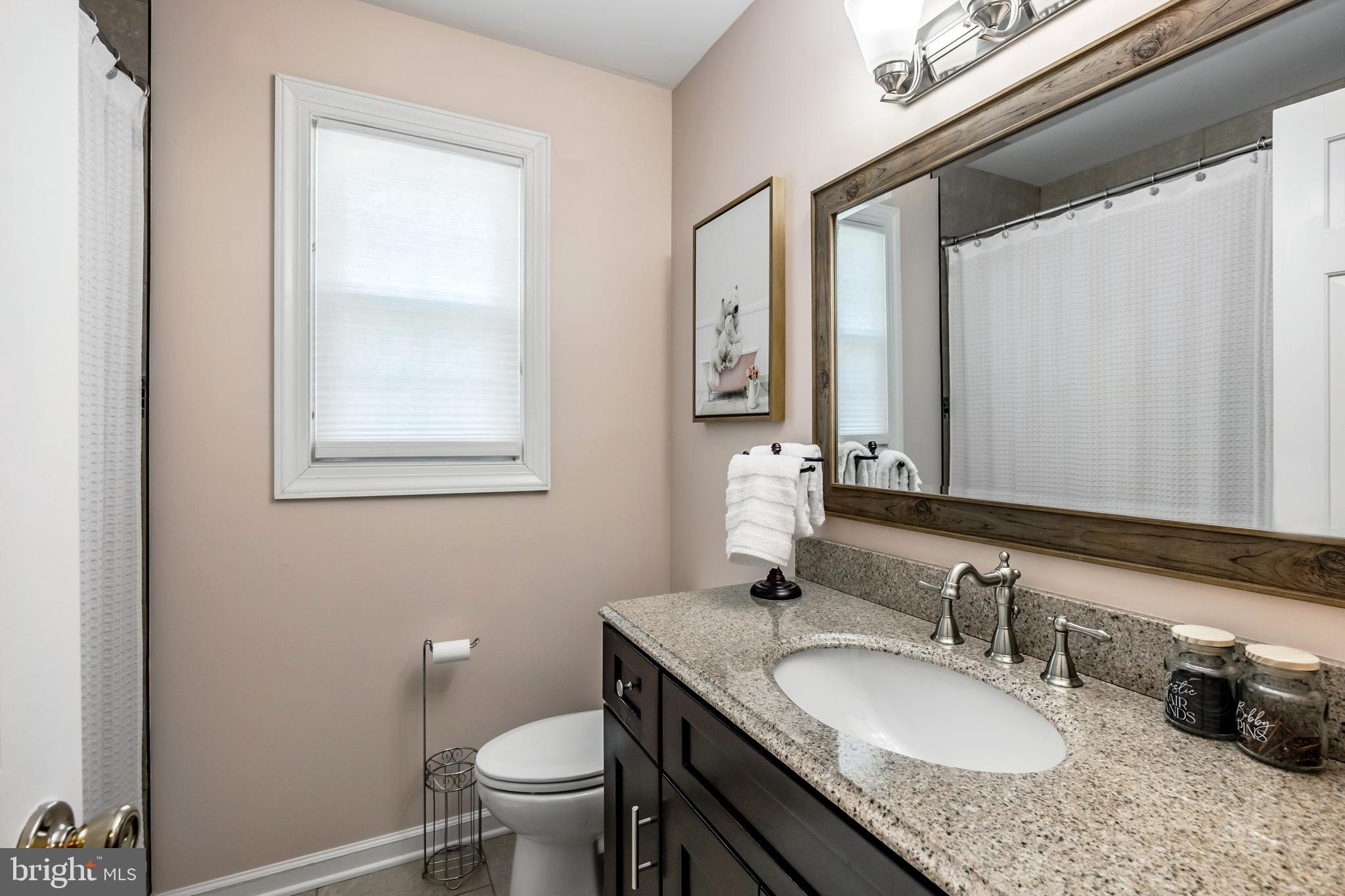512 Flora Circle Springfield, PA 19064 - Photo 30 of 46 a bathroom with a granite countertop sink toilet and mirror