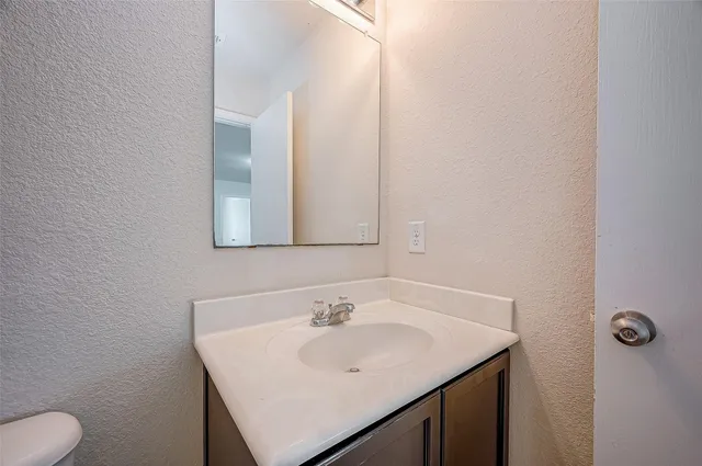 a bathroom with a sink toilet and mirror