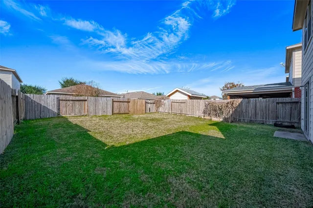a view of a house with backyard and a tree