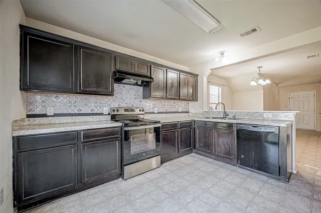 a kitchen with stainless steel appliances granite countertop a stove sink and cabinets