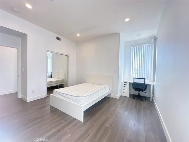 a spacious bedroom with a bed and a chair