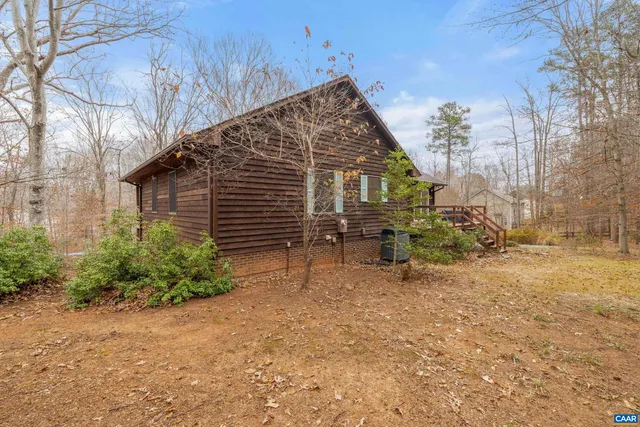 a view of a black gate with wooden floor and fence