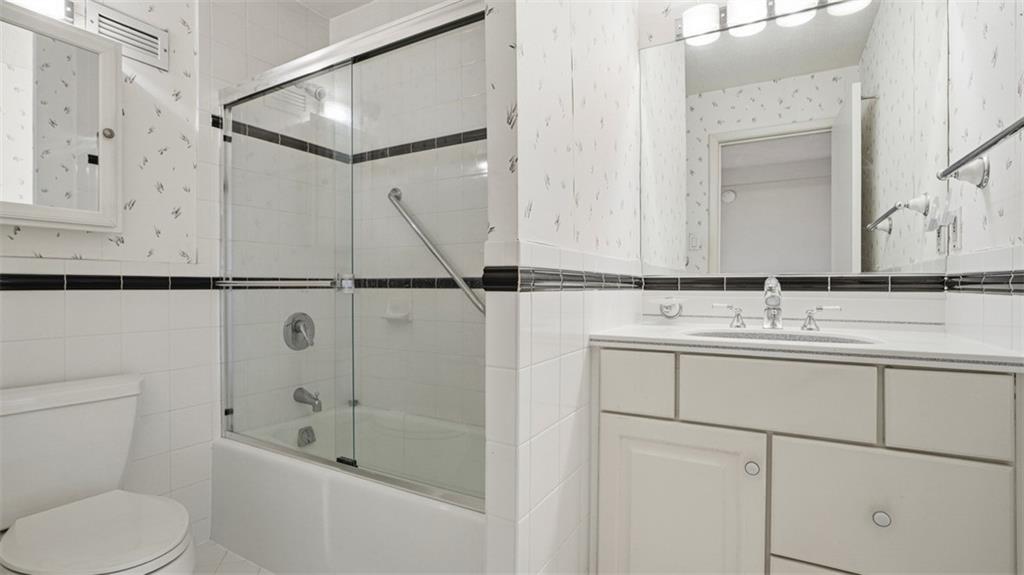 1160 Bower Hill Road, Unit 716A Mt. Lebanon, PA 15243 - Photo 26 of 36 Full Bathroom with white ceramic tile with black trim and glass shower doors and grab bars for safety.