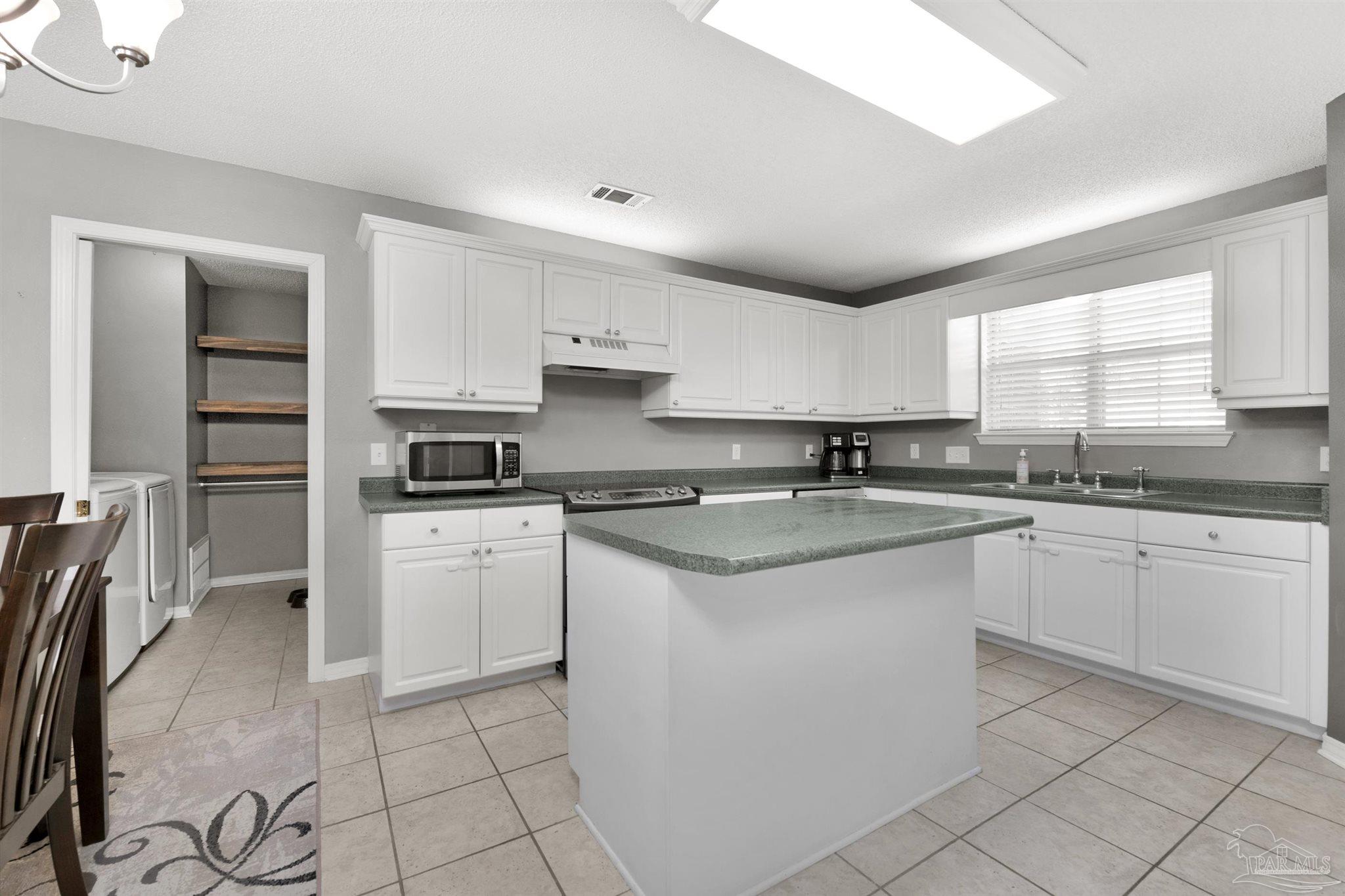 2702 Beacon Court Navarre, FL 32566 - Photo 1 of 29 a kitchen with granite countertop white cabinets sink and stainless steel appliances