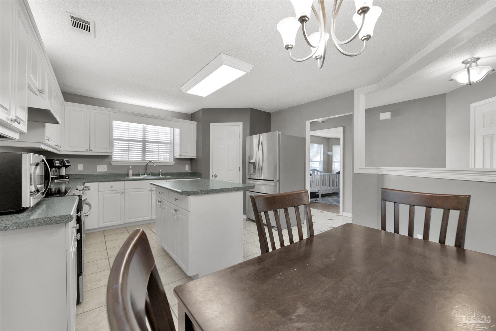 2702 Beacon Court Navarre, FL 32566 - Photo 11 of 29 a kitchen with cabinets and wooden floor