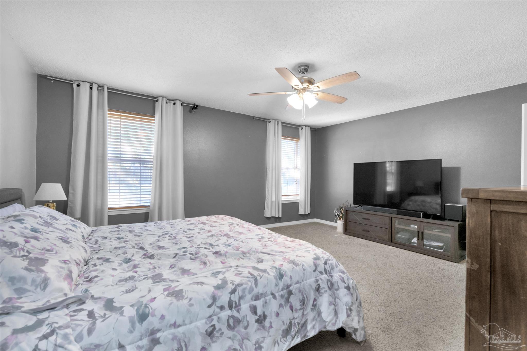 2702 Beacon Court Navarre, FL 32566 - Photo 17 of 29 a bedroom with a bed and a flat screen tv