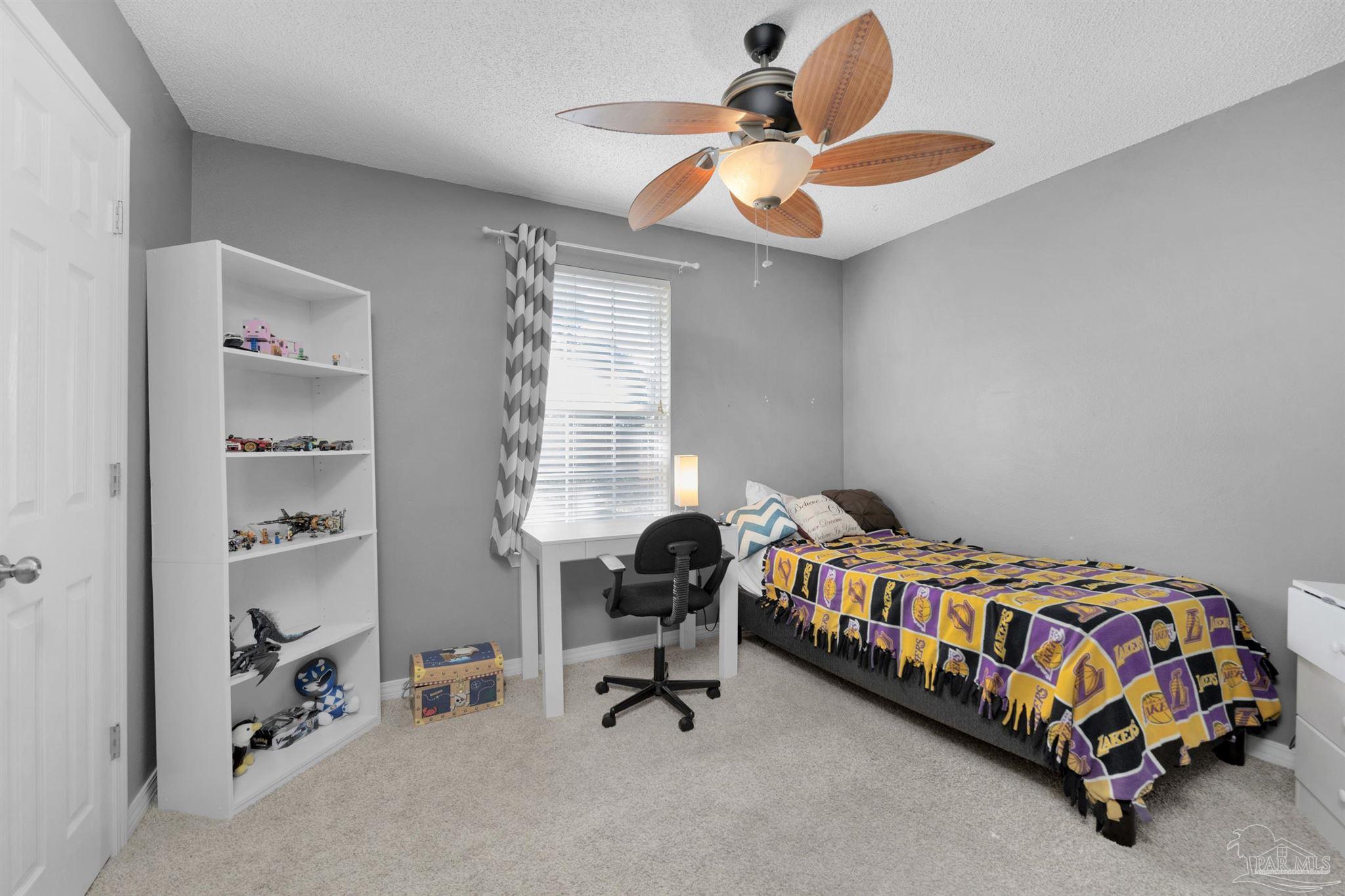 2702 Beacon Court Navarre, FL 32566 - Photo 20 of 29 a bedroom with a bed and a chandelier