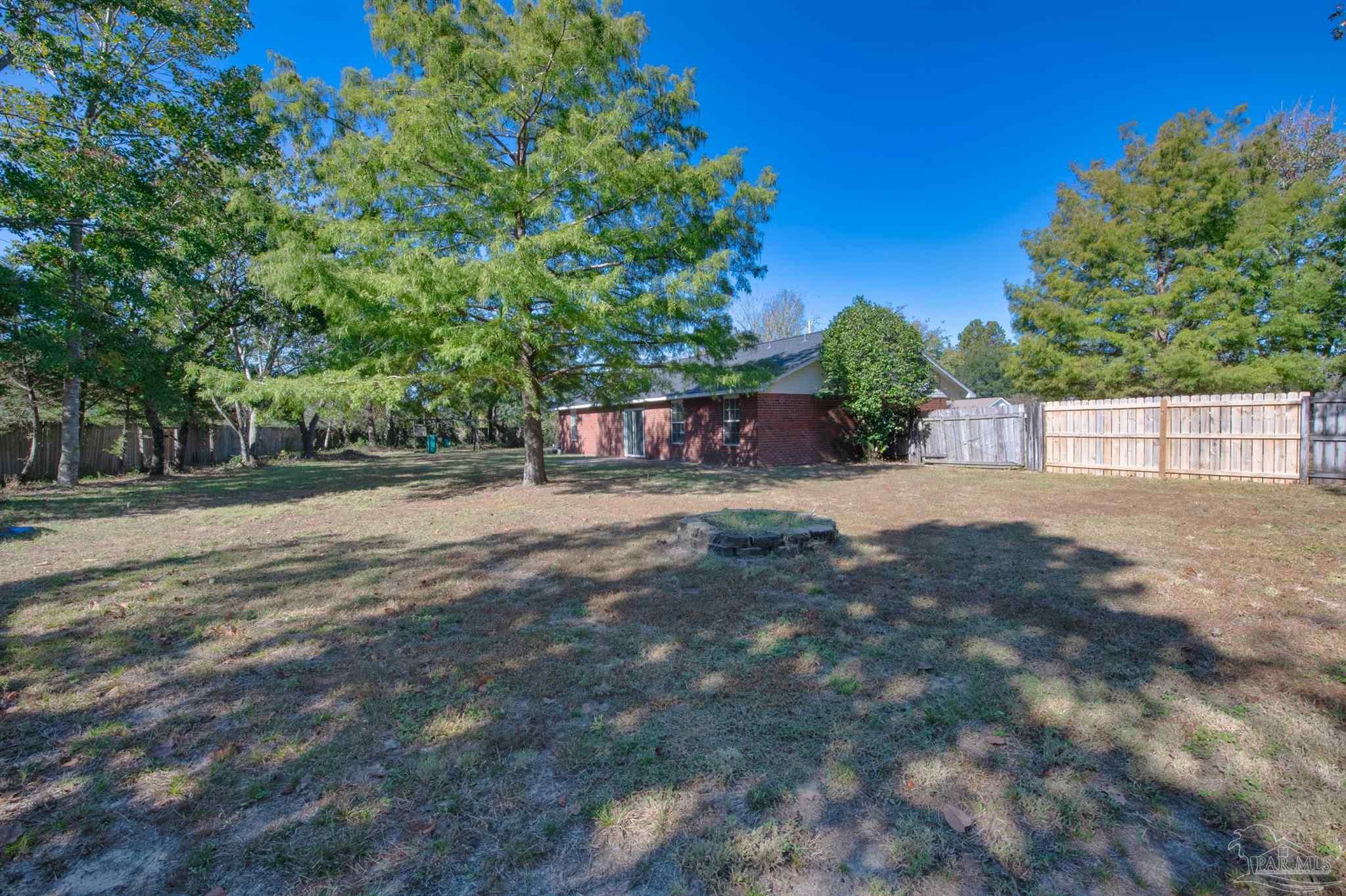2702 Beacon Court Navarre, FL 32566 - Photo 24 of 29 a view of a yard with plants and trees