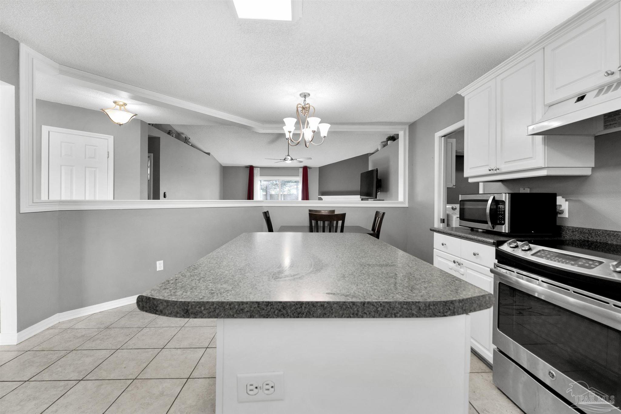 2702 Beacon Court Navarre, FL 32566 - Photo 10 of 29 a large white kitchen with granite countertop a stove and a sink