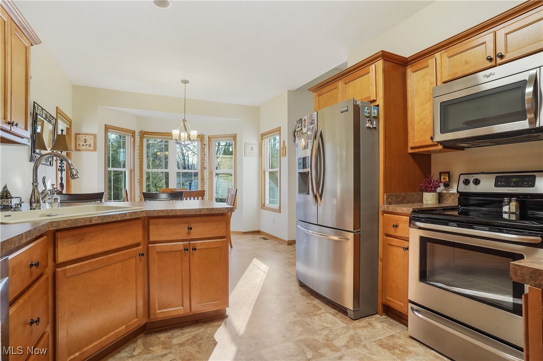 861 Susan Road Ravenna, OH 44266 - Photo 18 of 45 Kitchen with pendant lighting, stainless steel appliances, an inviting chandelier, and sink