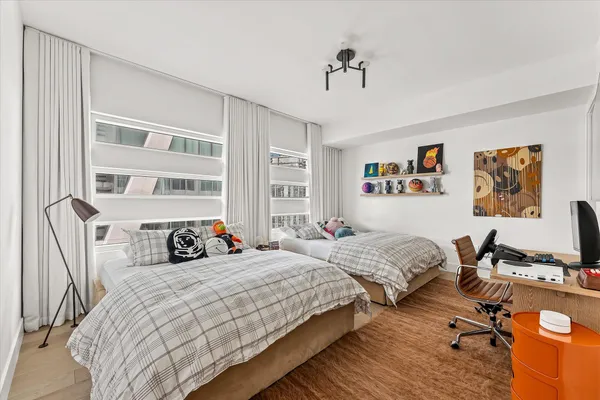 a bedroom with two beds and a desk