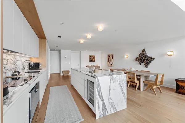 a view of a kitchen with kitchen island stainless steel appliances a dining table and chairs