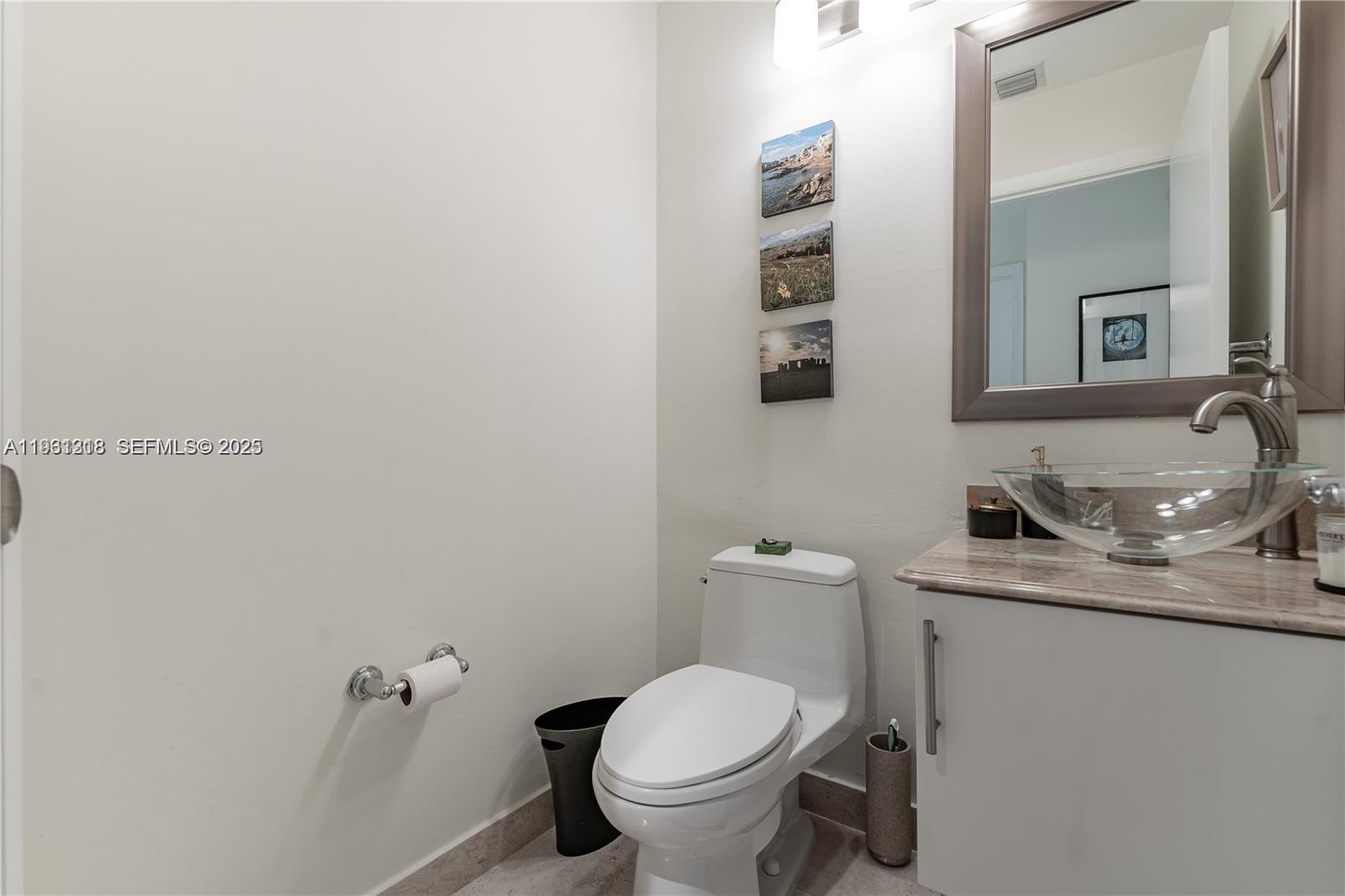 31 Southeast 5th Street, Unit 3716 Miami, FL 33131 - Photo 16 of 37 a bathroom with a granite countertop toilet sink and mirror