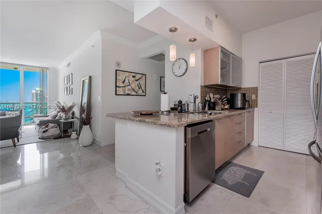 a view of a kitchen with sink and refrigerator