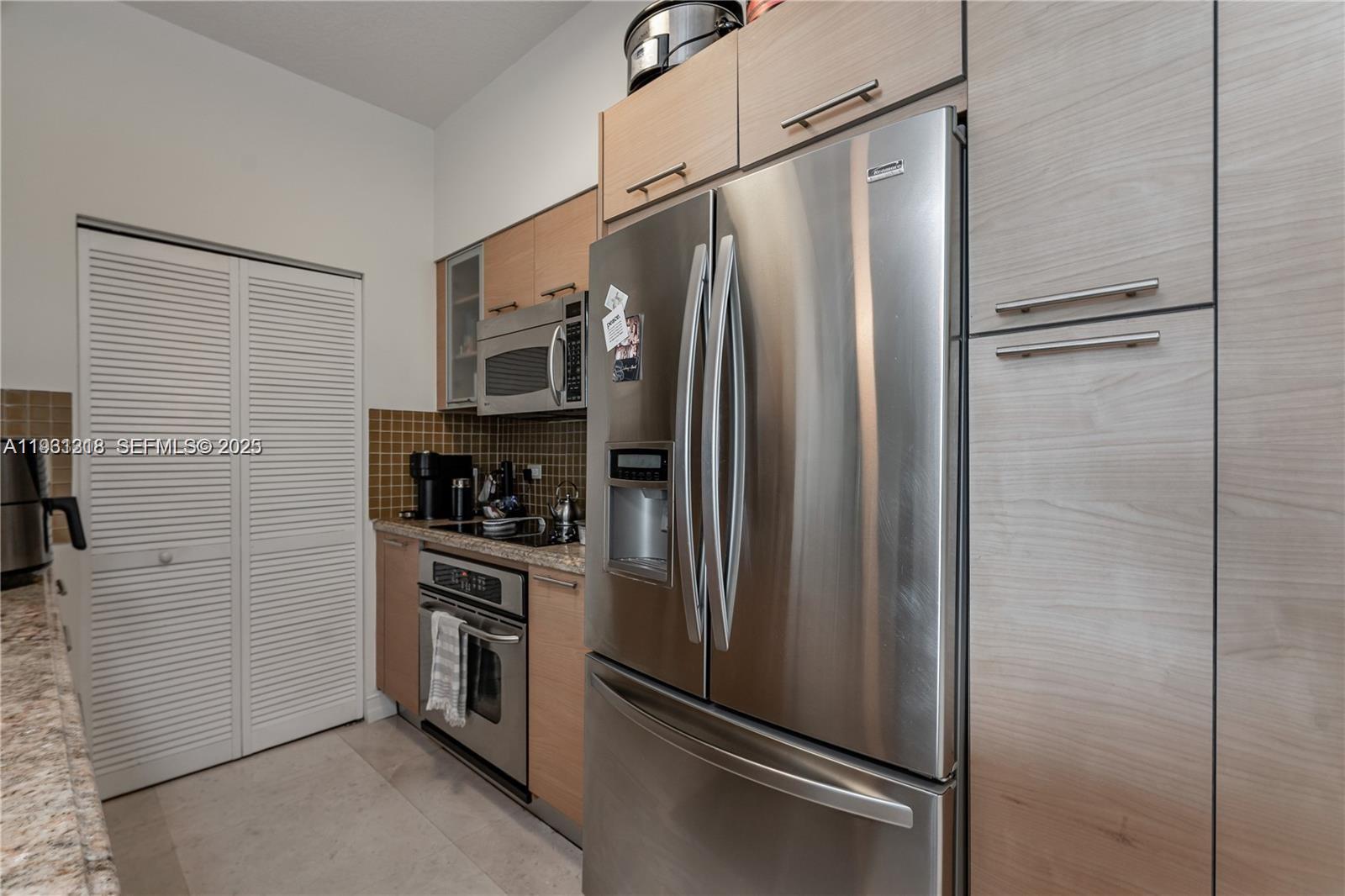 31 Southeast 5th Street, Unit 3716 Miami, FL 33131 - Photo 9 of 37 a metallic refrigerator freezer and a stove sitting inside of a kitchen