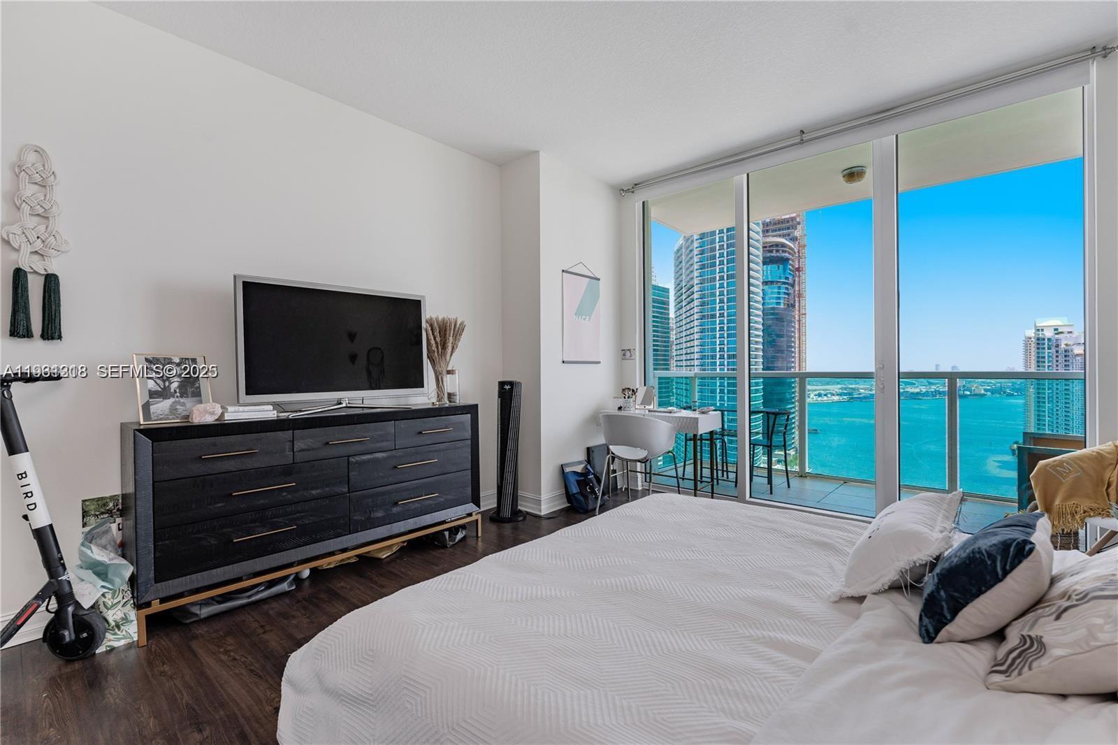 31 Southeast 5th Street, Unit 3716 Miami, FL 33131 - Photo 10 of 37 a bedroom with a bed a large window and flat screen television