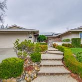 a front view of a house with a yard and potted plants