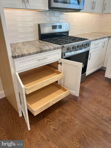 an empty room with wooden floor chandelier fan and windows
