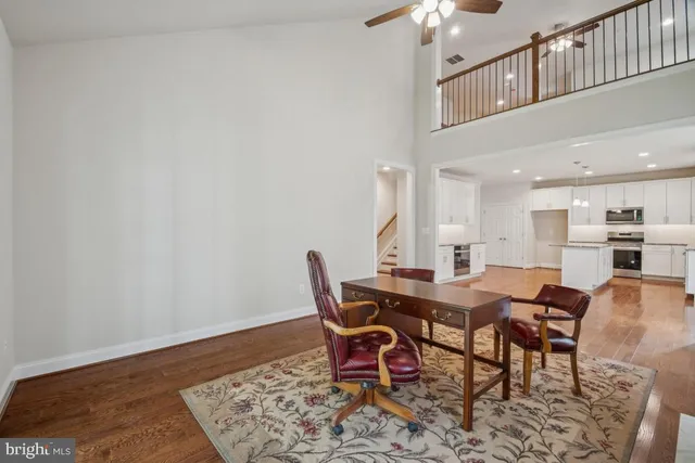 an empty room with wooden floor and fan