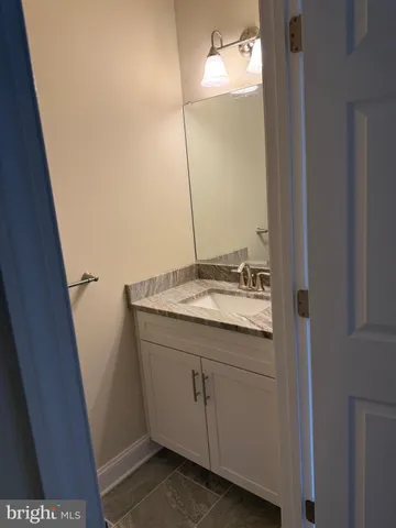 a kitchen with stainless steel appliances granite countertop a stove top oven a sink a dining table and chairs with wooden floor