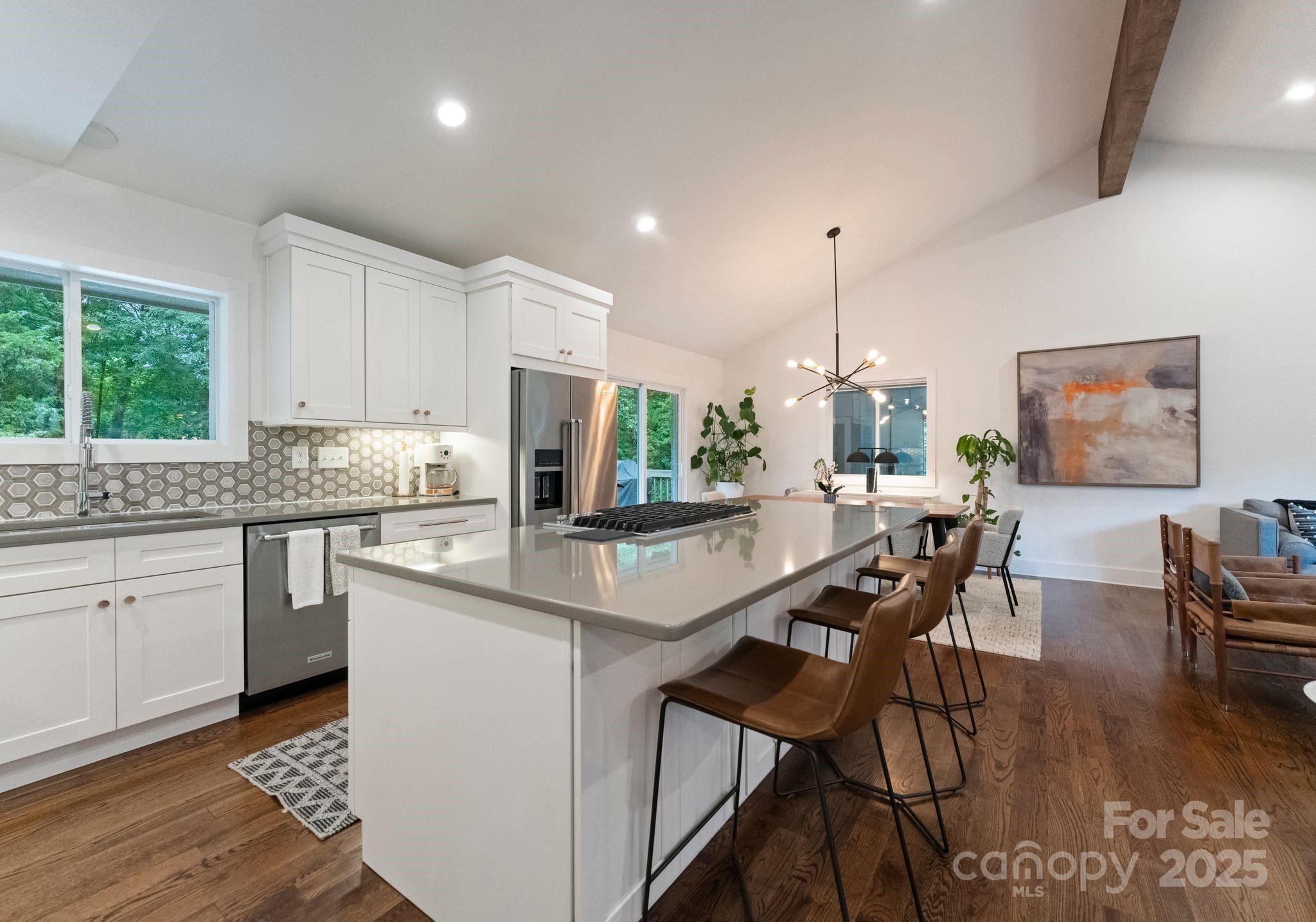 6527 Burlwood Road Charlotte, NC 28211 - Photo 16 of 43 a kitchen with kitchen island granite countertop a table chairs sink and cabinets