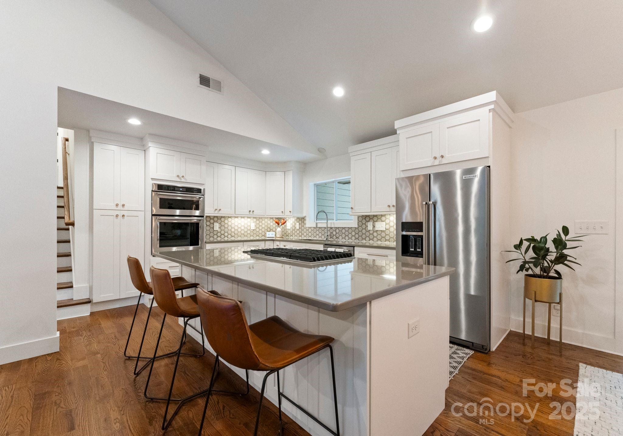 6527 Burlwood Road Charlotte, NC 28211 - Photo 17 of 43 a kitchen with stainless steel appliances a dining table chairs refrigerator and microwave