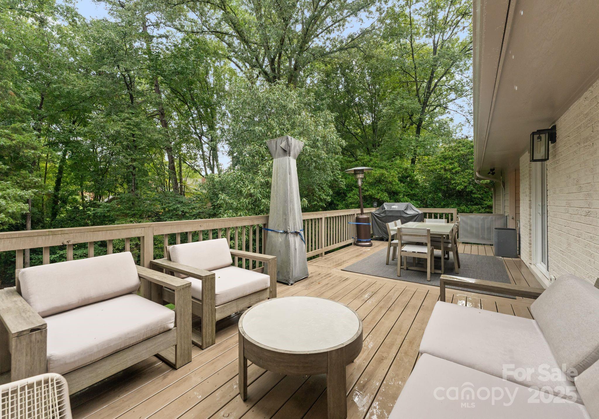 6527 Burlwood Road Charlotte, NC 28211 - Photo 39 of 43 a view of a patio with a dining table and chairs with two large trees
