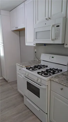 a white stove top oven sitting inside of a kitchen