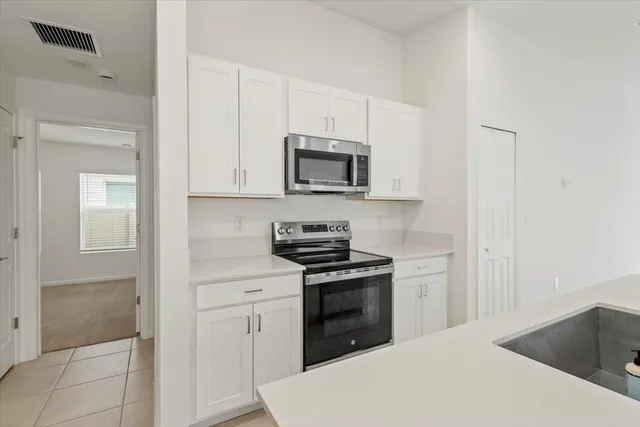 a kitchen with white cabinets and stainless steel appliances