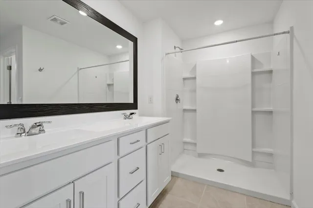 a bathroom with a shower sink and mirror