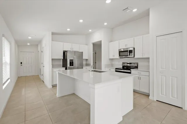 a kitchen with white cabinets and stainless steel appliances