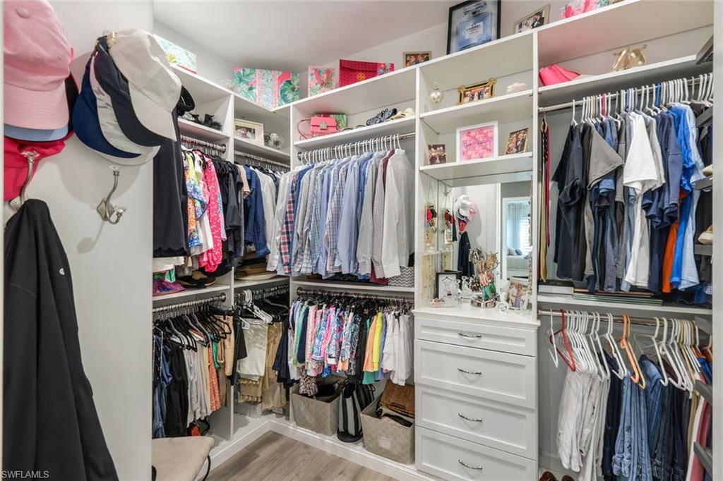 8935 Cappello Court Naples, FL 34119 - Photo 16 of 50 a view of walk in closet with clothes and shoes