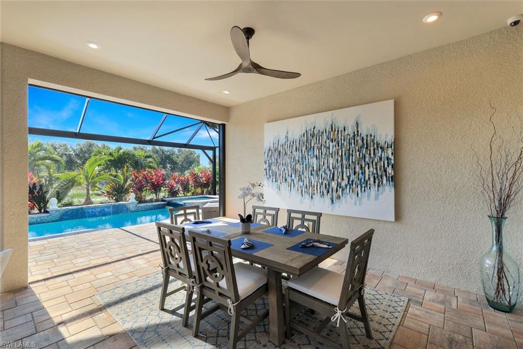 8935 Cappello Court Naples, FL 34119 - Photo 25 of 50 a dining room with furniture a rug and a floor to ceiling window
