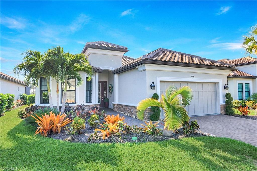 8935 Cappello Court Naples, FL 34119 - Photo 29 of 50 a front view of a house with a garden