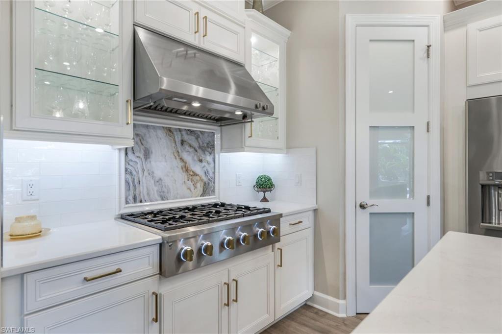 8935 Cappello Court Naples, FL 34119 - Photo 9 of 50 a kitchen with a stove and a wooden cabinets